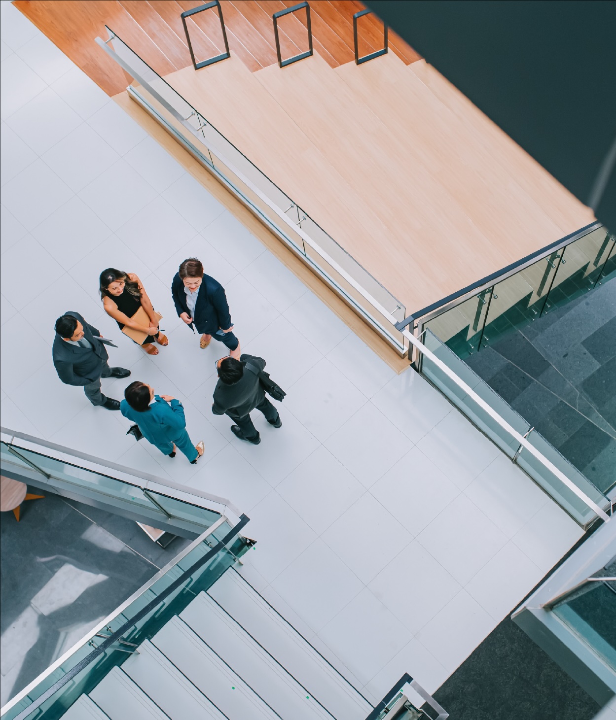A group of businesspeople chatting on an office walkway