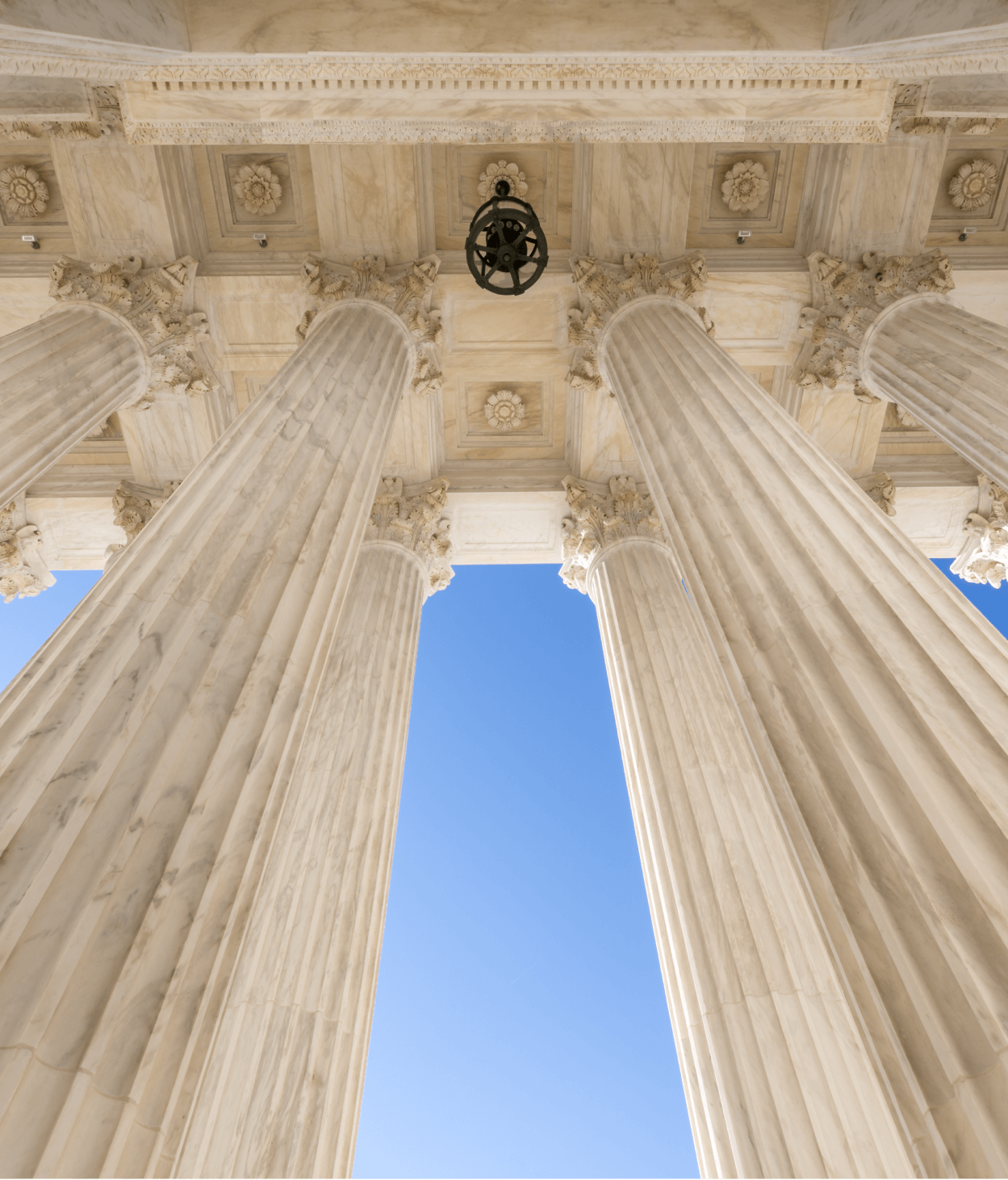 Photo taken from below government building looking up at architectural columns